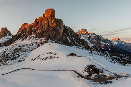 Panoramaaufnahme einer verschneiten Berglandschaft bei Sonnenuntergang.