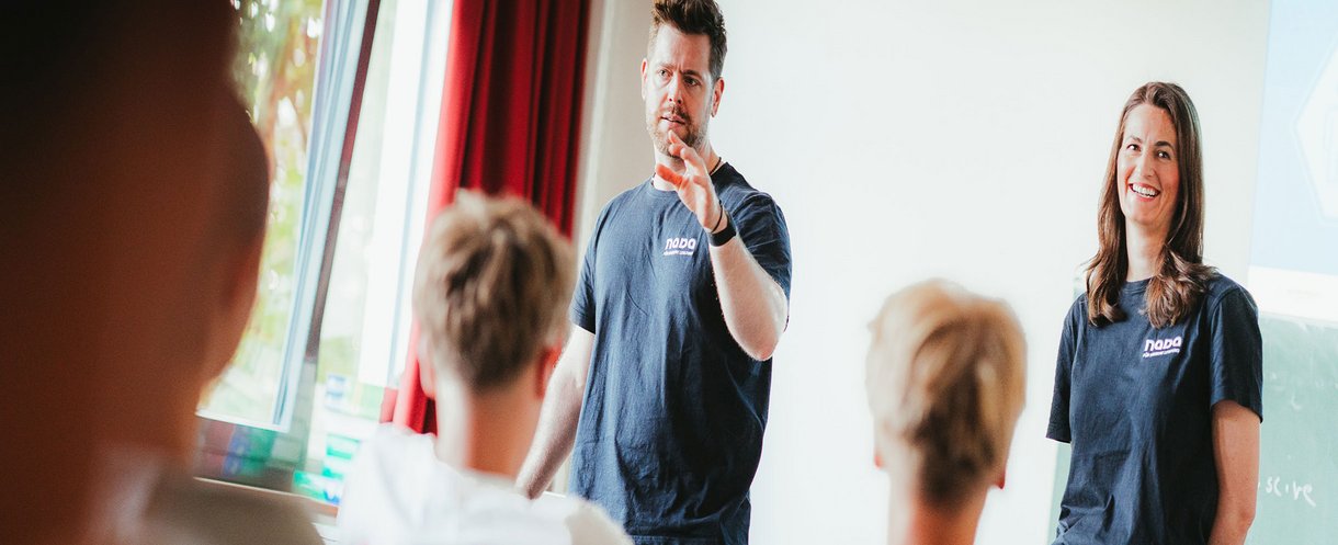 Mitarbeitende der NADA informieren eine Gruppe von Teilnehmenden im Rahmen einer Anti-Doping-Präventionsveranstaltung.