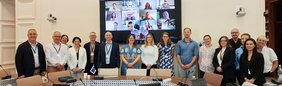 Teilnehmende des Treffens der Advisory Group on Science in Paris vor einem großen Bildschirm mit zugeschalteten Online-Teilnehmenden.