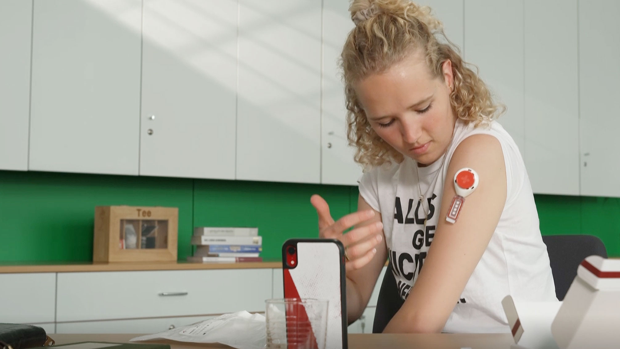 Anwendung eines Dried Blood Spot-Tests durch eine Athletin mit Gerät am Oberarm
