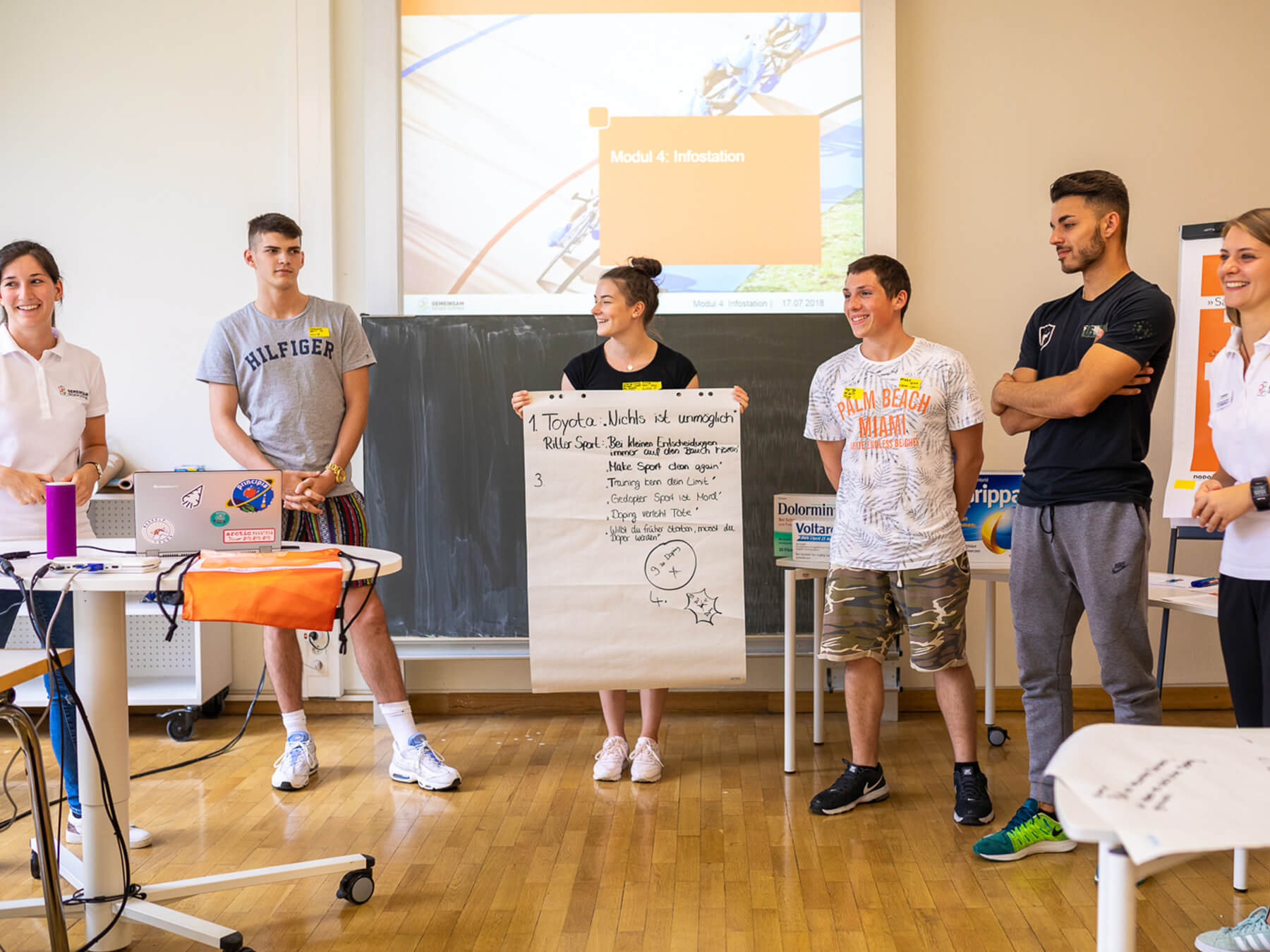 Students stand in front of a group with a poster